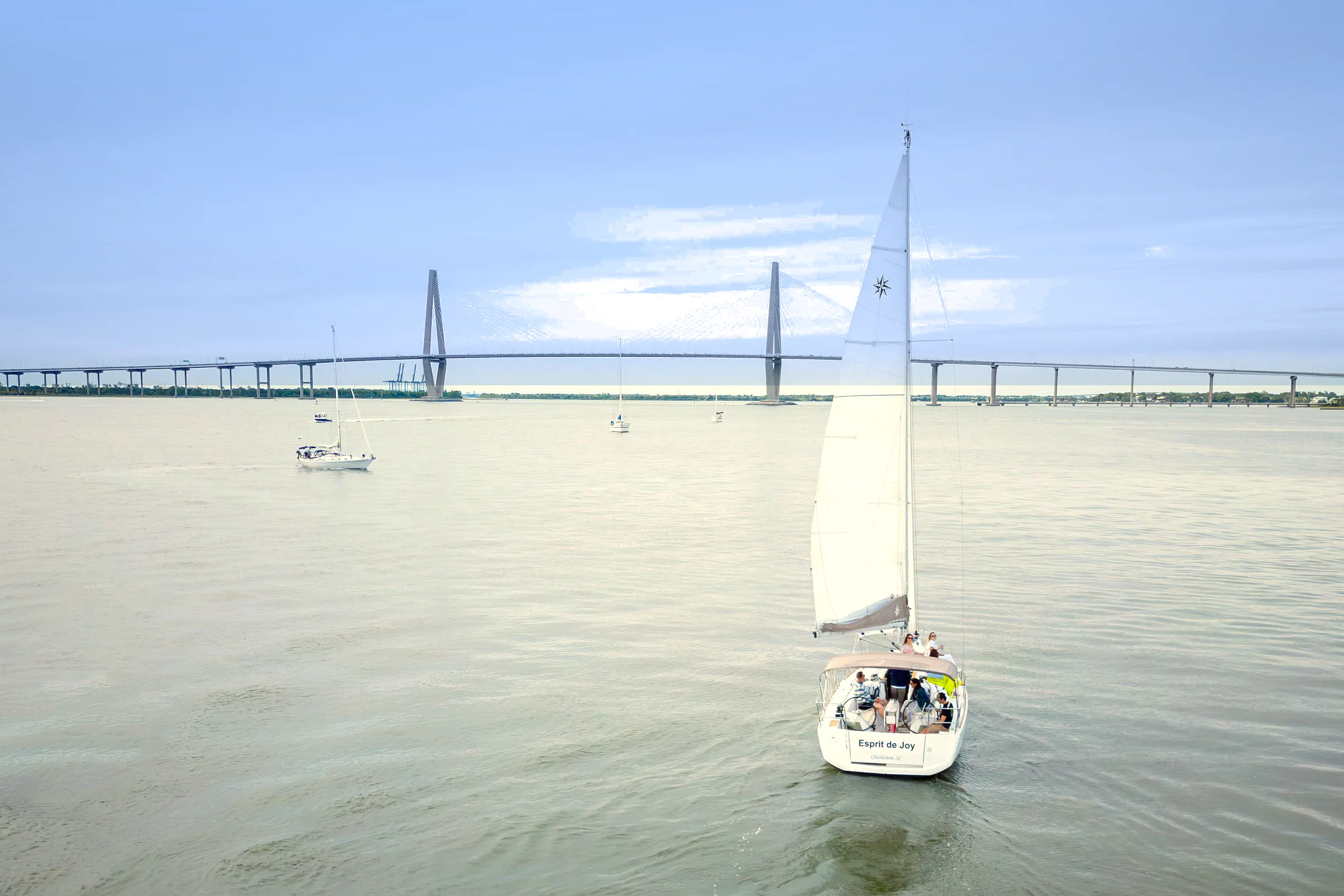 Aerial view of the sailboat Esprit de Joy on Charleston Harbor with the Ravenel Bridge behind
